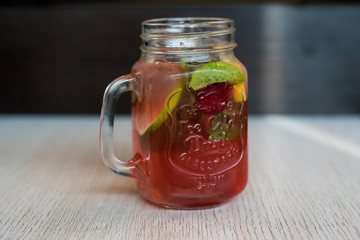 A girl in a red dress with long hair, takes pictures of food, rolls standing on a wooden stand and a blue background on the phone