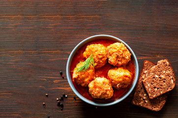 Fototapeta na wymiar Meat balls in tomato sauce on wooden background