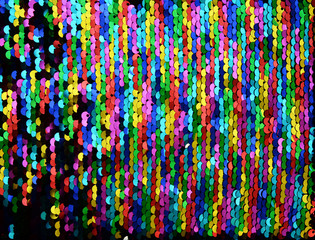 Sequins close-up macro. Abstract background with multicolor sequins on the fabric. Texture scales...