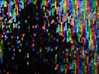 Sequins close-up macro. Abstract background with multicolor sequins on the fabric. Texture scales...