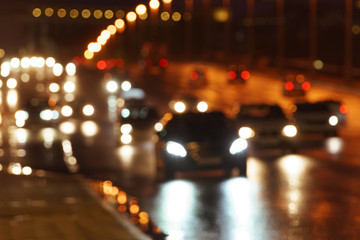 Defocused image of hard night for drivers. Big traffic in the city. In the summer urban highway...