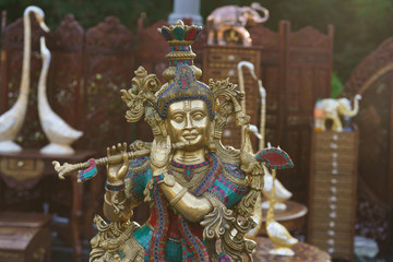 Obraz premium Figurine of Krishna playing the flute. Indian souvenir shop. Idols of Radha Krishna