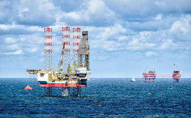 Oil rigs and supply vessels at sea