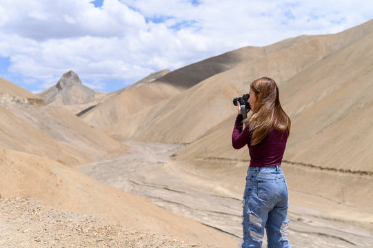 Nature photographer, traveller concept. Young asian woman taking photos of landscape view in Ladakh, North india