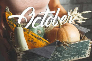 October text on autumn vegetables in wooden box. Close up. Farm editorial. Nature calendar...