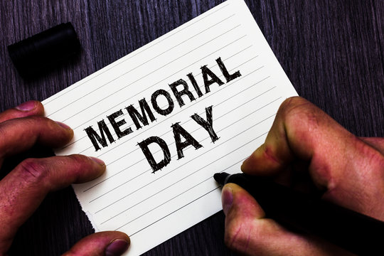 Text sign showing Memorial Day. Conceptual photo To honor and remembering those who died in military service Man holding marker notebook page communicate ideas Wooden background
