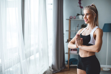 Fototapeta na wymiar Slim girl practicing yoga at home, wellness, wellbeing.
