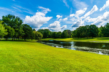 Fototapeta na wymiar Park with lake and blue sky and clouds