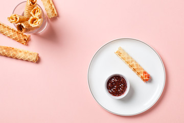 Wafer rolls with a sweet sauce. On a multicolored background. Minimalism