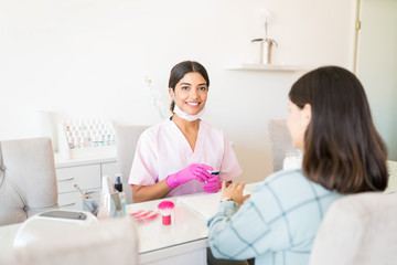 Young Cosmetician And Client At Beauty Salon