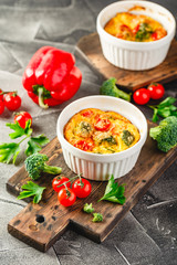 Vegetable frittata with broccoli, red bell pepper and red onion in cast iron skillet. View from above