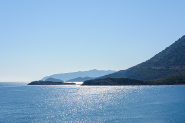 beautiful morning view of the calm Mediterranean sea and mountains. the sun is reflected in the glare of the water