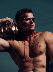 Scary and bloody muscular zombie man with pumpkin in outdoor. Day of The Dead. Halloween. Scary...