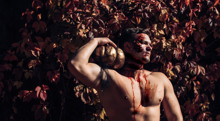 Bloody nude man with head injury, bloody theme, halloween theme, killer. Naked man holding creepy...