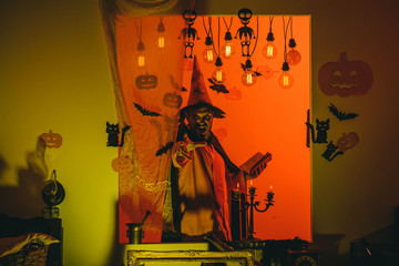 Handsome man in wizard costume hat for Halloween on fairytale background. Magic, enchantment,...
