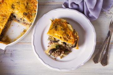 Traditional moussaka on plate and in baking dish