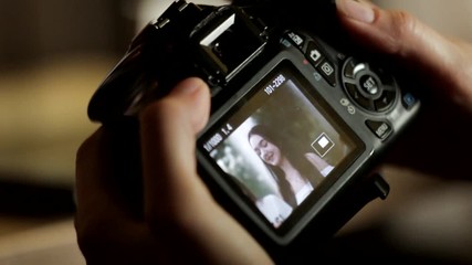 The photographer examines the picture in the camera, selects the best shots from the photo shoot