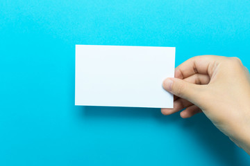Fototapeta premium Hand holding up a note card on a blue background