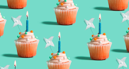 Tasty celebratory cupcakes with decorative lit candles