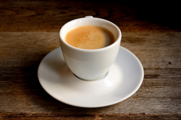 White cup of coffee on old boards.