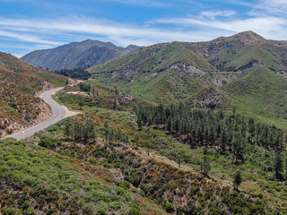 Asphalt road bends through Angeles National forests mountain, California, USA. Thin road winds between a ridge of hills and mountains at high altitude