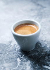 Cup of coffee on bright stone background. Copy space