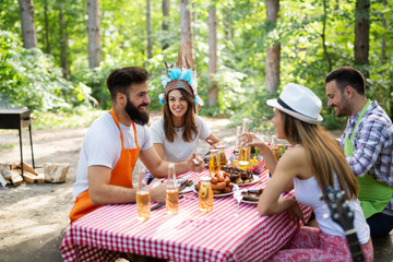 Group of friends having a barbecue and grill party in nature