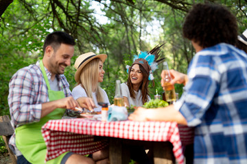 Group of happy friends having a barbecue party in nature