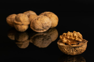 Lot of whole ripe brown walnut isolated on black glass
