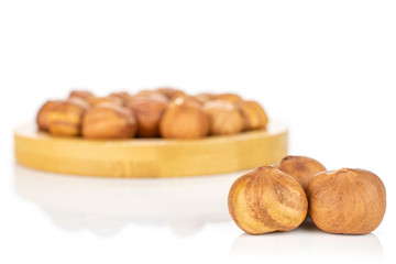 Lot of whole ripe brown hazelnut three are in the front and the rest is in the back isolated on white background
