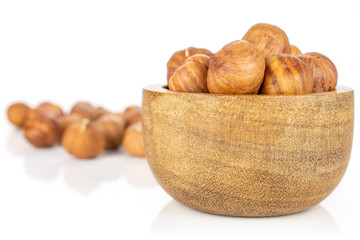 Lot of whole ripe brown hazelnut in tiny wooden bowl isolated on white background