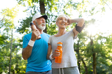 Fototapeta premium Mature couple drinks water to replenish energy and to hydrate
