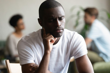 Unhappy black male loner feel hurt sitting alone