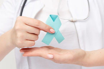 Female doctor holding blue ribbon isolated