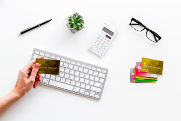 Banker work place with credit card in hands, keyboard and calculator on white background top view