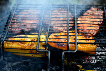 Barbecue outdoors steak and bell pepper in the smoke on the grill.