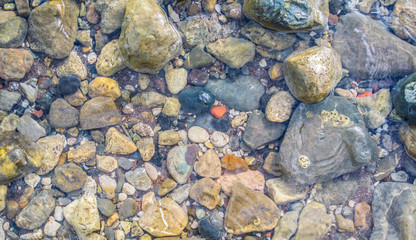 Big and small stones in the sea water. Stone background image.