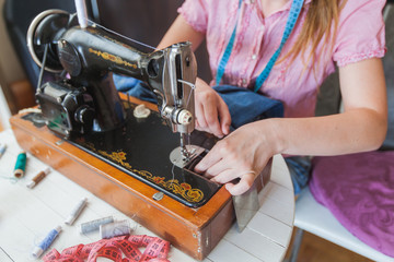  female tailor hands changing thread on old sewing machine