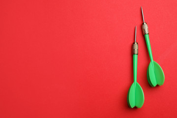 Green dart arrows on red background, flat lay with space for text