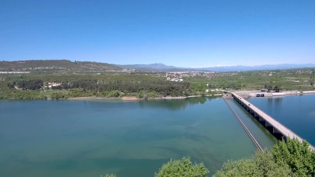 Aerial view of Aliakmonas  river with car bridge in a plain with crops, Aliakmonas river, Veria Greece, bottom-up movement by drone