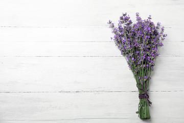Beautiful tender lavender flowers on white wooden table, top view. Space for text