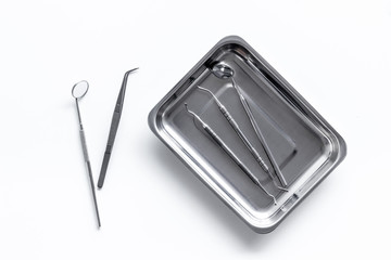 dentist instruments on white doctor's office desk background top view