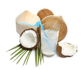 Glass of coconut milk and nuts on white background