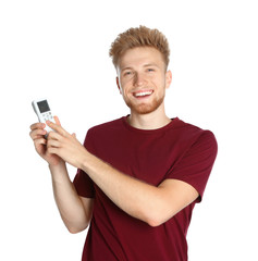 Fototapeta premium Young man with air conditioner remote on white background