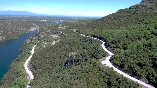 Aerial view of river in valley and country road on the side, Veria Greece,  motion in front of a drone