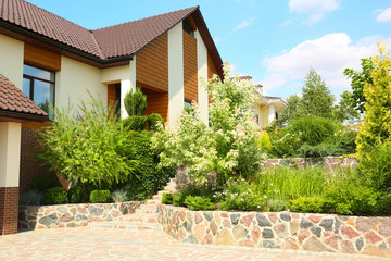 Landscape with modern house and beautiful garden on sunny day