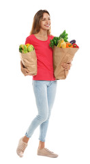 Young woman with bags of fresh vegetables isolated on white