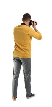 Young photographer with professional camera on white background, back view