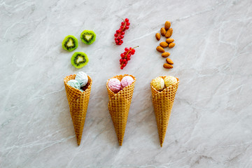 Sweets pattern with ice cream, nuts and fruit on stone background top view copyspace