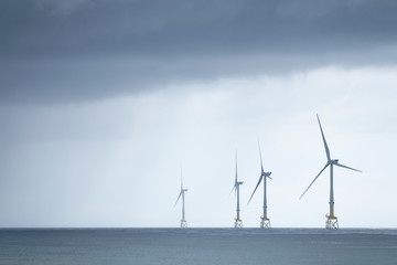 Wind turbines at electric power farm in the North Sea in Aberdeen for renewable energy production...